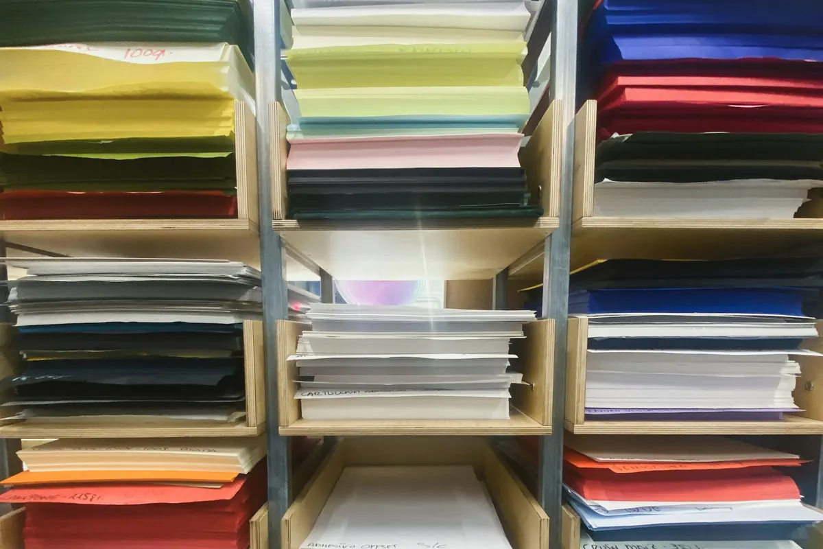 Stapels gekleurd papier in een kast
